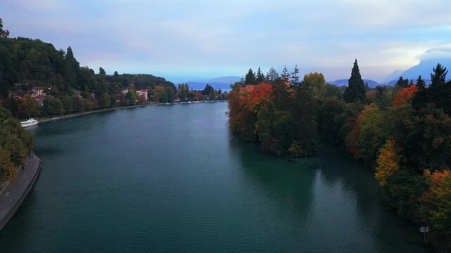Thunersee Lake Thun Flusswelle calm Aare River aerial drone Thun Switzerland Schweiz Fall Autumn morning clouds Swiss Alps Grindelwald Jungfrau mountains Bernese Oberland Interlaken forwards motion