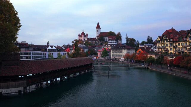 Thun Castle Flusswelle Aare River Schloss Thun Thunersee Switzerland Schweiz Europe Autumn Fall aerial drone morning grey skies yellow birches tree pedestrian walkway Bernese Oberland circle right