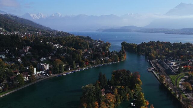 Swiss Alps Grindelwald Jungfrau mountains Bernese Oberland Thunersee Lake Thun Flusswelle Aare River aerial drone Thun Switzerland Schweiz Fall Autumn sunny morning clouds Interlaken circle left