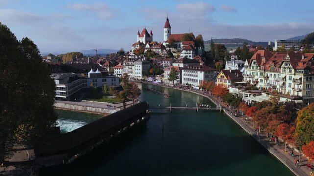 Thun Castle Aare River Schloss Thun Thunersee Switzerland Schweiz Europe aerial drone Autumn Fall pedestrian walkway sunny blue sky clouds yellow birches tree Bernese Oberland upwards jib pan
