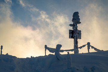 Winter landscape on Połonina Caryńska in the Bieszczady Mountains, Poland. Snow-covered ridge, strong frost, dramatic clouds and clear blue sky during a cold winter day. Popular trekking area known fo