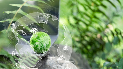 Green technology and ESG concept. Digital globe with CO2 reduction icons and eco-friendly symbols on laptop with nature background for sustainable business development.