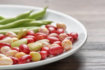 Colorful beans of different varieties and sizes on white plate