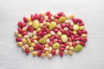 Colorful beans of different varieties and sizes on white table