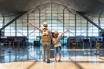 Female tourist and her son with raised arms in airport