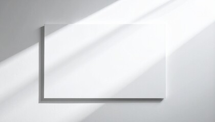 Elegant horizontal blank white canvas mockup, bathed in natural diagonal sunlight and soft shadows on a minimalist wall, providing a clean and versatile backdrop for your design