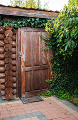 Garden wooden shed front view with mop on a corner.