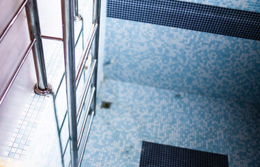 Indoor private empty swimming pool in gray and blue tones.