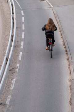 Overhead cycling bicycle commute on asphalt road curve with shoulder lines guiding transport along denmark route in soft daylight today