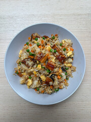 A plate of unagi fried rice with vegetables.