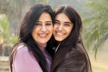 Indian happy mother having fun caring, hugging, embracing, enjoyment and bonding loving with her young daughter. Concept of Mother and Daughter Love