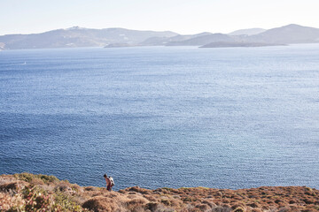 man on a cliff over the sea in patmos island © dimitris