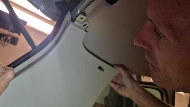 Car interior repair, man removing plastic panel, automotive maintenance process, detailed vehicle service