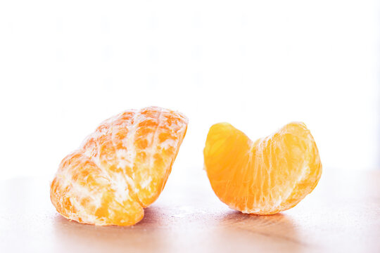 Sliced ​​tangerine on a counter, isolated on a white background