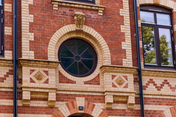 Obraz premium Architectural Detail Of A Red Brick Building With Round Window And Decorative Elements In Landskrona Sweden