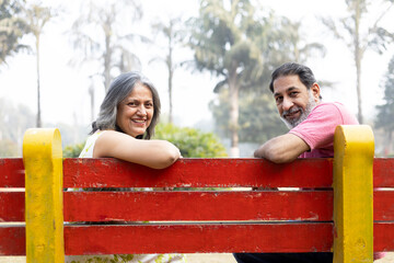 Indian Senior happy couple enjoying in park. Elderly couple embracing, spending time and having fun in vacation time. Senior citizens care hugging or date at the park for romance after retirement. Sen © Pix4Ads