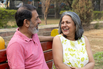 Indian Senior happy couple enjoying in park. Elderly couple embracing, spending time and having fun in vacation time. Senior citizens care hugging or date at the park for romance after retirement. Sen © Pix4Ads