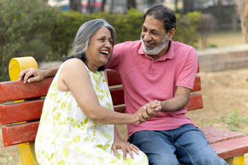 Indian Senior happy couple enjoying in park. Elderly couple embracing, spending time and having fun in vacation time. Senior citizens care hugging or date at the park for romance after retirement. Sen © Pix4Ads