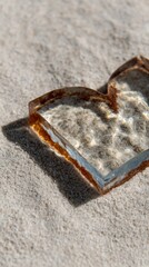 Rustic heart-shaped glass shard, sunlit on sandy desert, echoes lost eras, solstice rituals, and International Sand Day