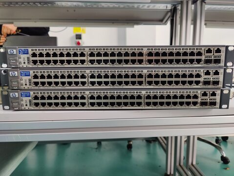 Front View of Stacked HP ProCurve Enterprise Network Switches with Multiple Ethernet Ports and Internal View of Circuit Board Featuring Power Supply and Integrated Processing Units