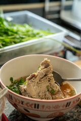 Traditional Asian pork soup served in a bowl with clear broth, tender meat, and fresh herbs. Homemade comfort food representing authentic local cuisine and simple everyday dining.