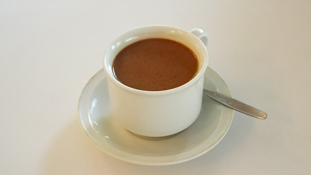 Traditional coffee cup on a saucer, placed on a wooden table