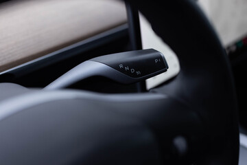 Close-up of details of automatic transmission and gear stick. Handle of electric car gearbox control. Design details of minimalist concept of electric car. Automatic gear lever and gear shift