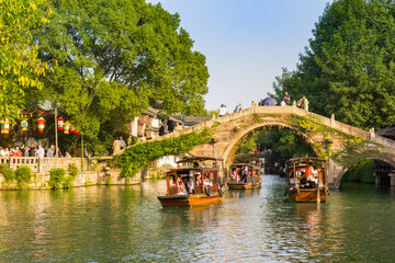 Wooden boats going under the Renji bridge in Wuzhen, China