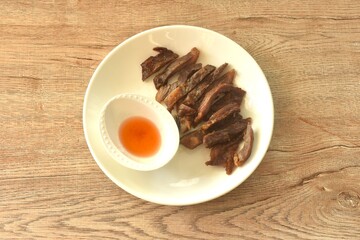 fried crispy salty fermenting beef fat meat with pepper on plate dipping spicy and sour chili sauce