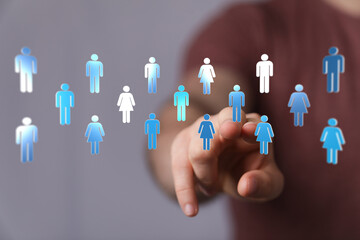 Hand touching digital human icons representing a connected global community. Illustrating social...