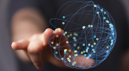 A person's hand reaches towards a glowing network sphere, symbolizing the digital world, connectivity, and technological advancement.