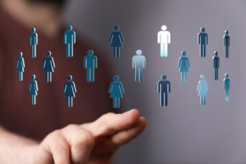 Abstract graphic representation of people, teamwork, connection, and social network. Hand interacts with human figures floating.