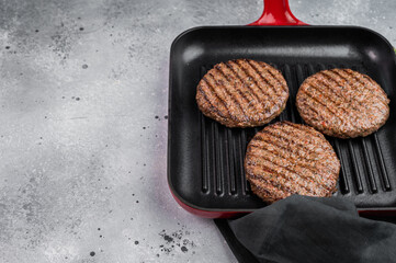Cooked mixed meat patties made from beef and lamb in grill pan. Light stone background with copy space for food design.