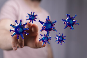 Abstract image showing a hand interacting with digital 3D virus models, representing disease or contagion. Con
