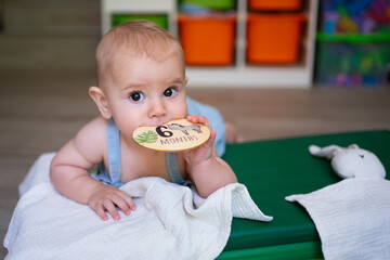 Baby boy celebrating six months milestone lying on play mat