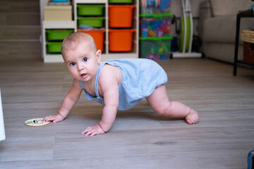 Baby girl crawling on floor celebrating six months milestone