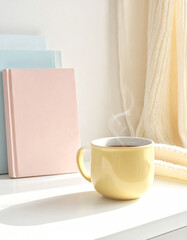 Yellow coffee mug with double handles and books