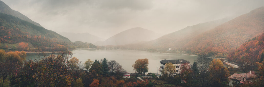 Moody Lakeside Landscape with Fall Foliage and Morning Fog