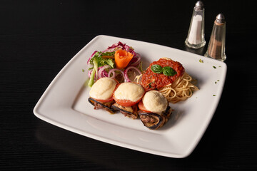 plate of spaghetti and eggplant stuffed with beef