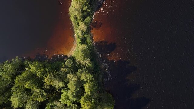 Lake island with green trees viewed from above and side, Northern Europe
