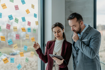 Middle-Aged Man and Young Woman Working in Modern Office with Sticky Notes – HR and Creative © Vladimir Borovic