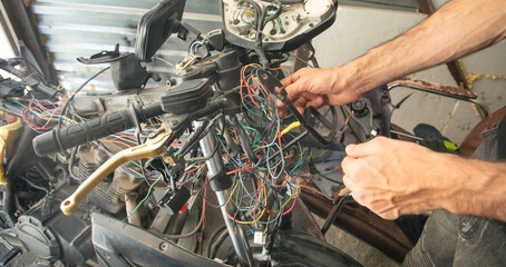 Caucasian electric repairing motorcycle electrical system.