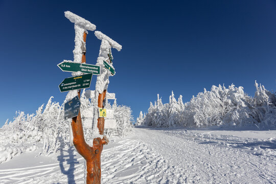 Wegweiser am Gipfel &ndash; Vereiste Orientierungstafeln unter strahlend blauem Himmel in der verschneiten Berglandschaft