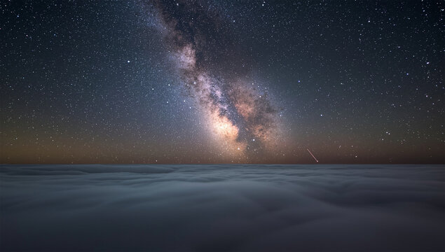 雲海の上に立ち上がる天の川を広角で捉えた静かな深夜の星景