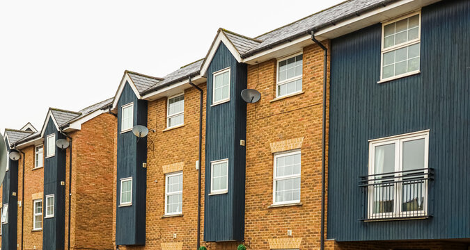 Modern terraced housing development showing contemporary architecture with brick and dark siding townhouses