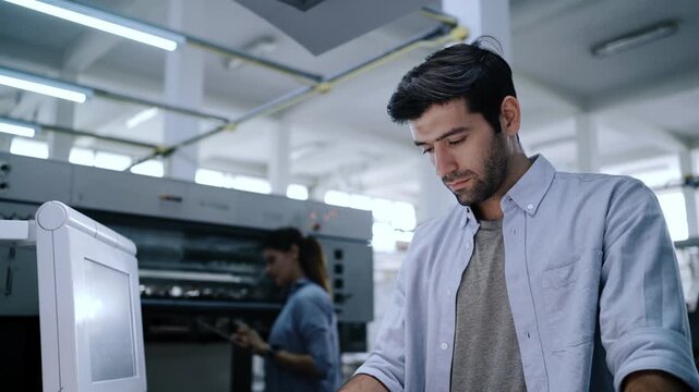 Graphic engineers checking print quality of graphics in printing factory