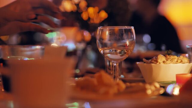 Woman takes clear water glass at celebration table, shows calm mindful lifestyle