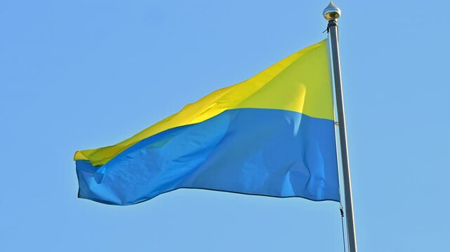 Ukrainian National Flag in Slow Motion Waving in Wind on Clear Summer Day with Blue Sky Background