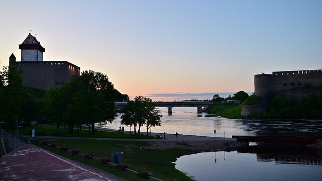 Narva River Border Bridge at Dusk Connecting Estonia and Russia. Narva Castle on One Side and Ivangorod Fortress on the other.