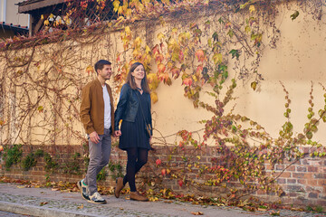 Couple walking by wall with autumn ivy